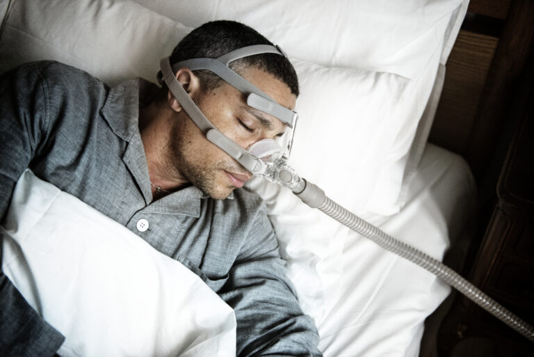 A man sleeping with a sleep apnea CPAP machine on who is looking for cpap alternatives